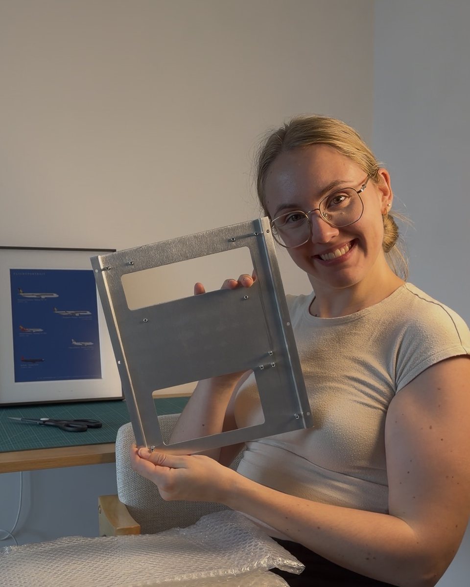 Audrey holding the frame's aluminium plate, a finished print behind her.